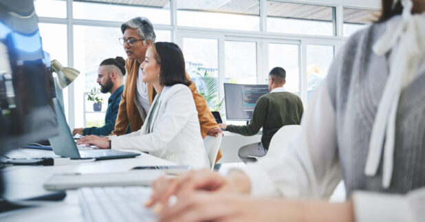 women sitting at a desk and troubleshooting how to update drivers on a pc